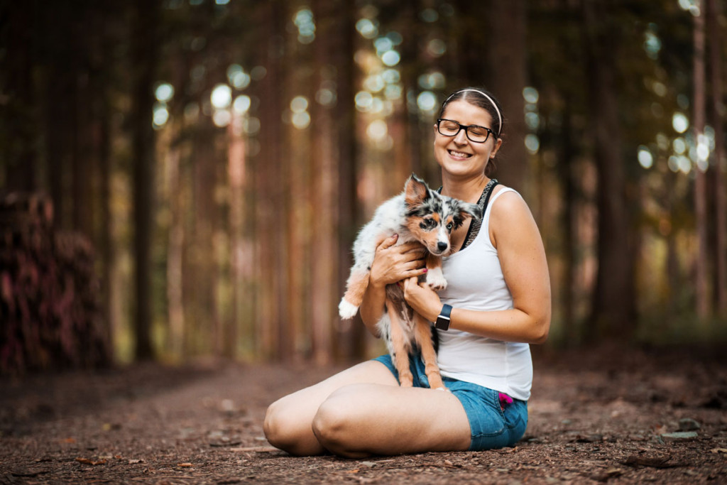 Minnie miniaturní americký ovčák vyskakující z náruče majitelky